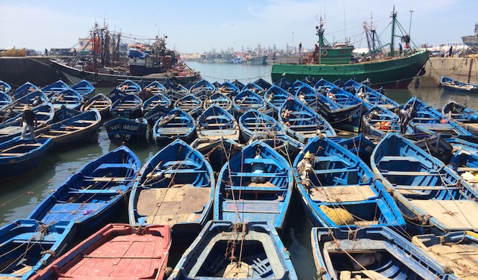 Muitos barcos de pesca azul em esoiria em Marrocos, amarrados um ao outro no porto