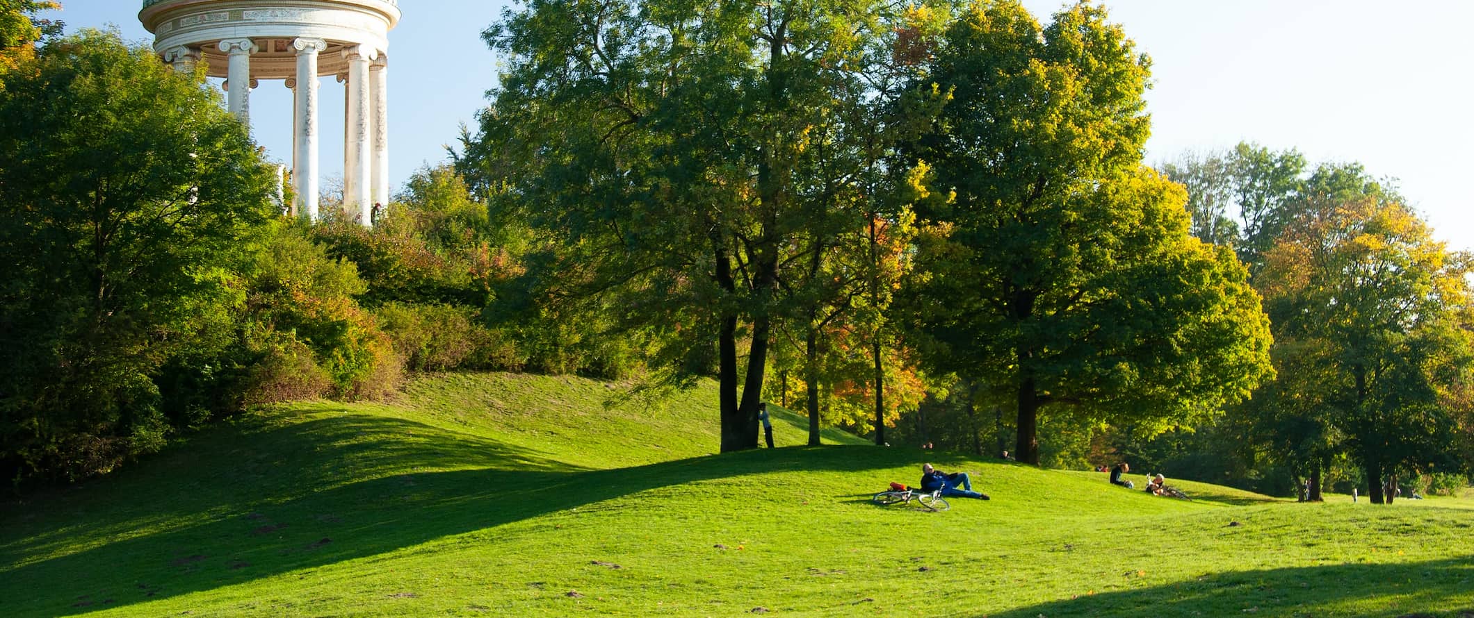 Um magnífico campo verde com moradores locais descansando no verão em Munique, Alemanha
