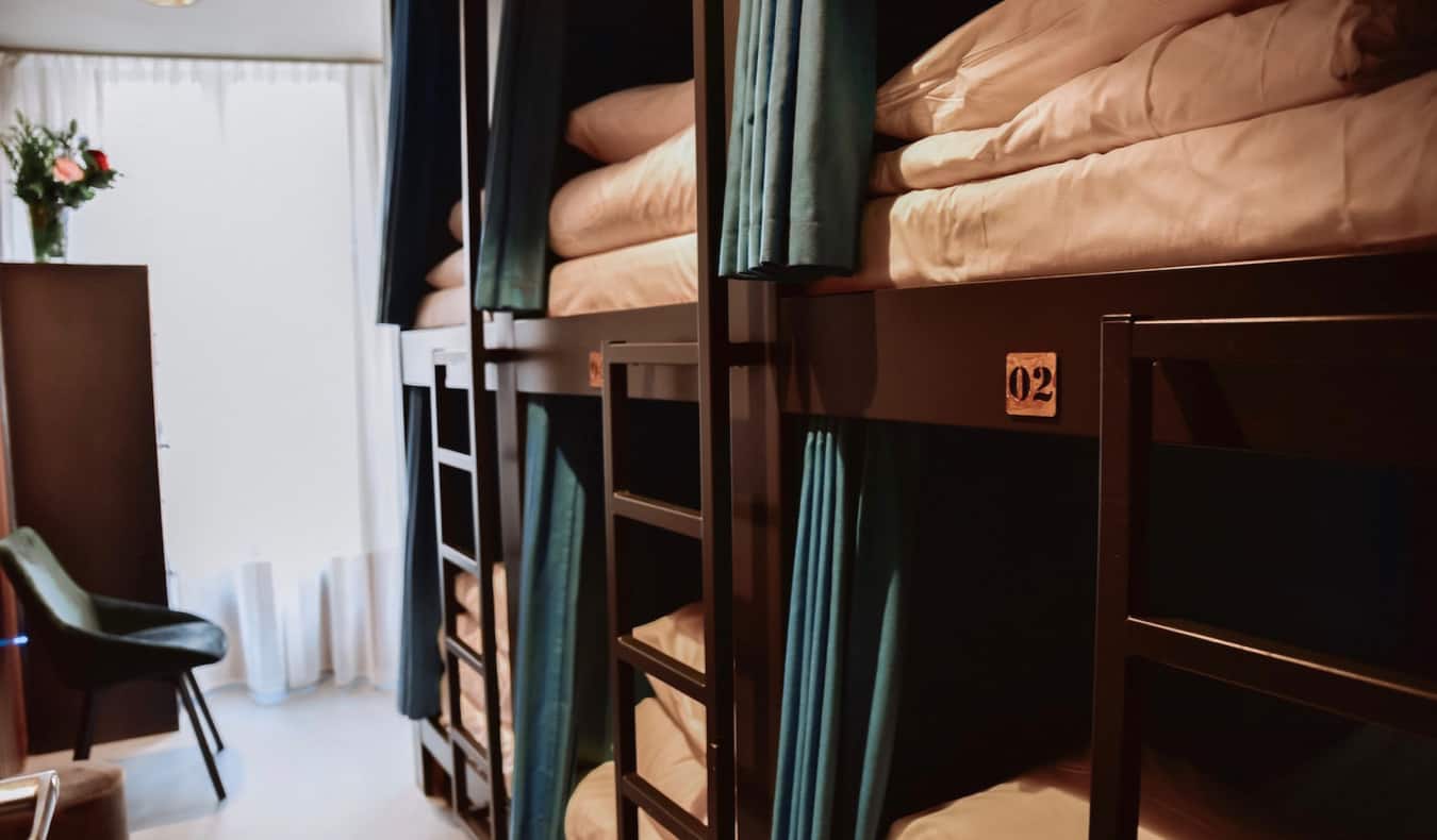 Um fechamento de camas escuras de doi s-toques de madeira com cortinas para solidão no albergue Durty Nellys Inn
