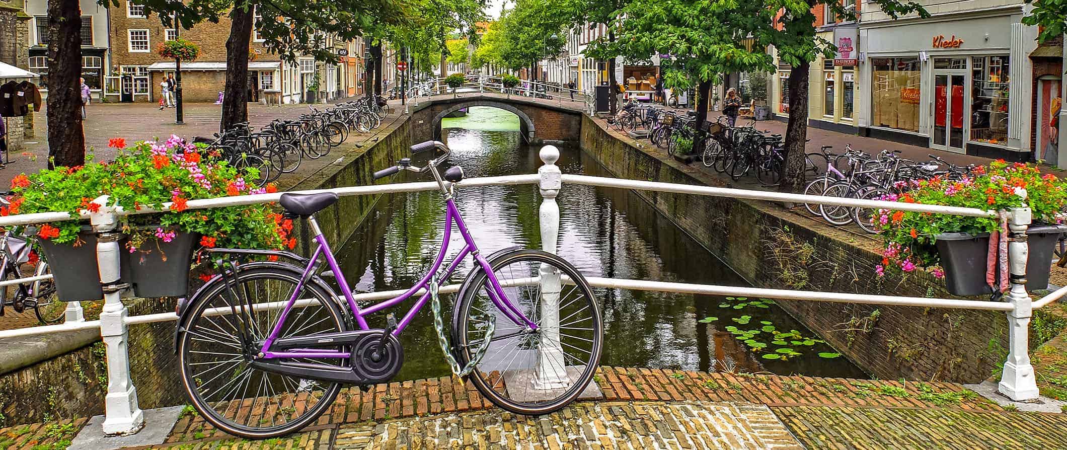 Vista do canal na Holanda com uma bicicleta encostada na ponte