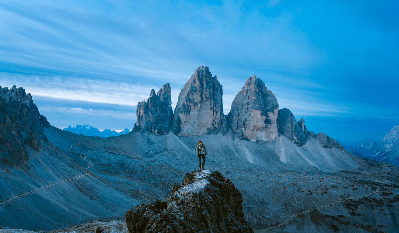 Um viajante solitário fica em uma montanha e olha para longe