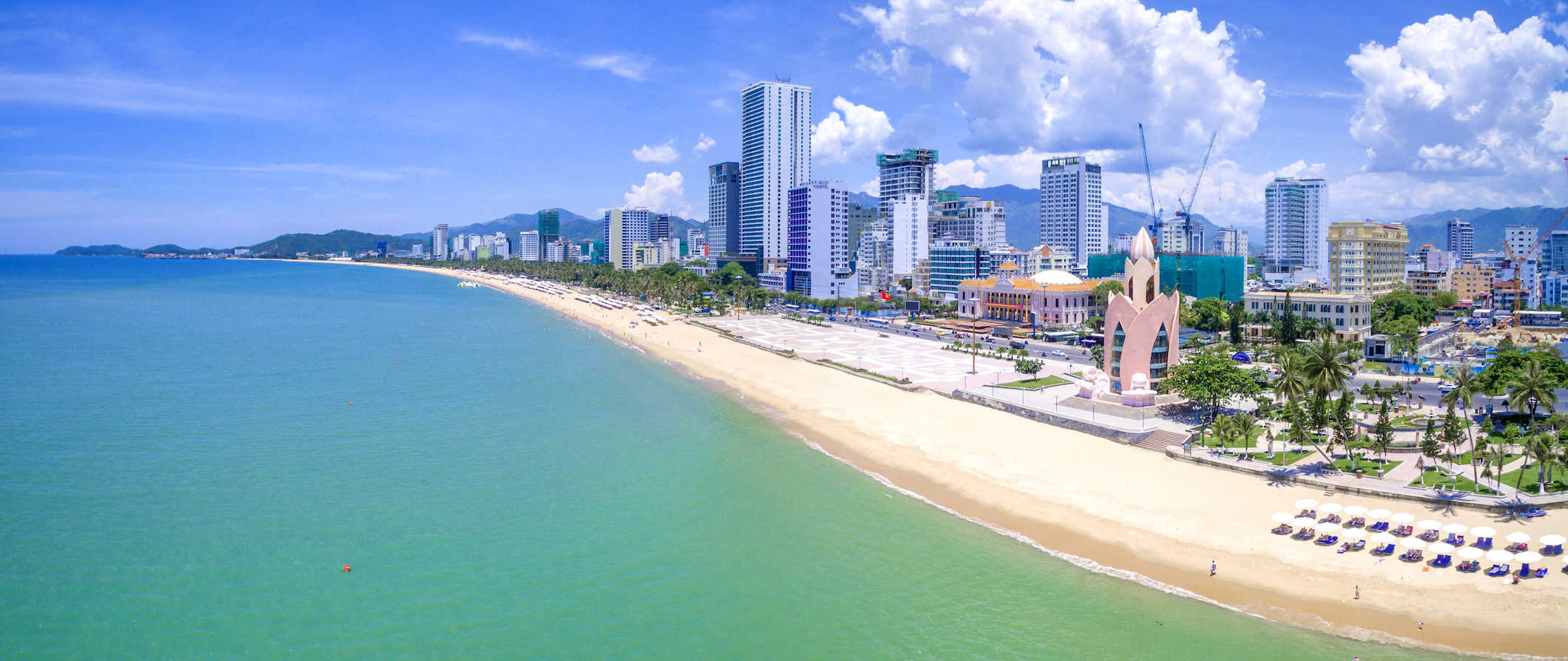 Cena da praia na costa de Nhazhang, Vietnã, com um horizonte da cidade se elevando ao longo da costa