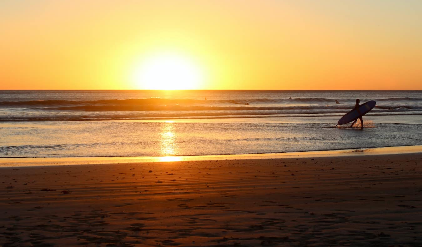 Sunset de ouro épico na costa de San Huang del Sur na Nicarágua com um surf à distância