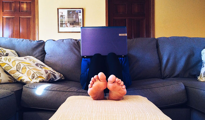 um homem sentado em um sofá com um laptop