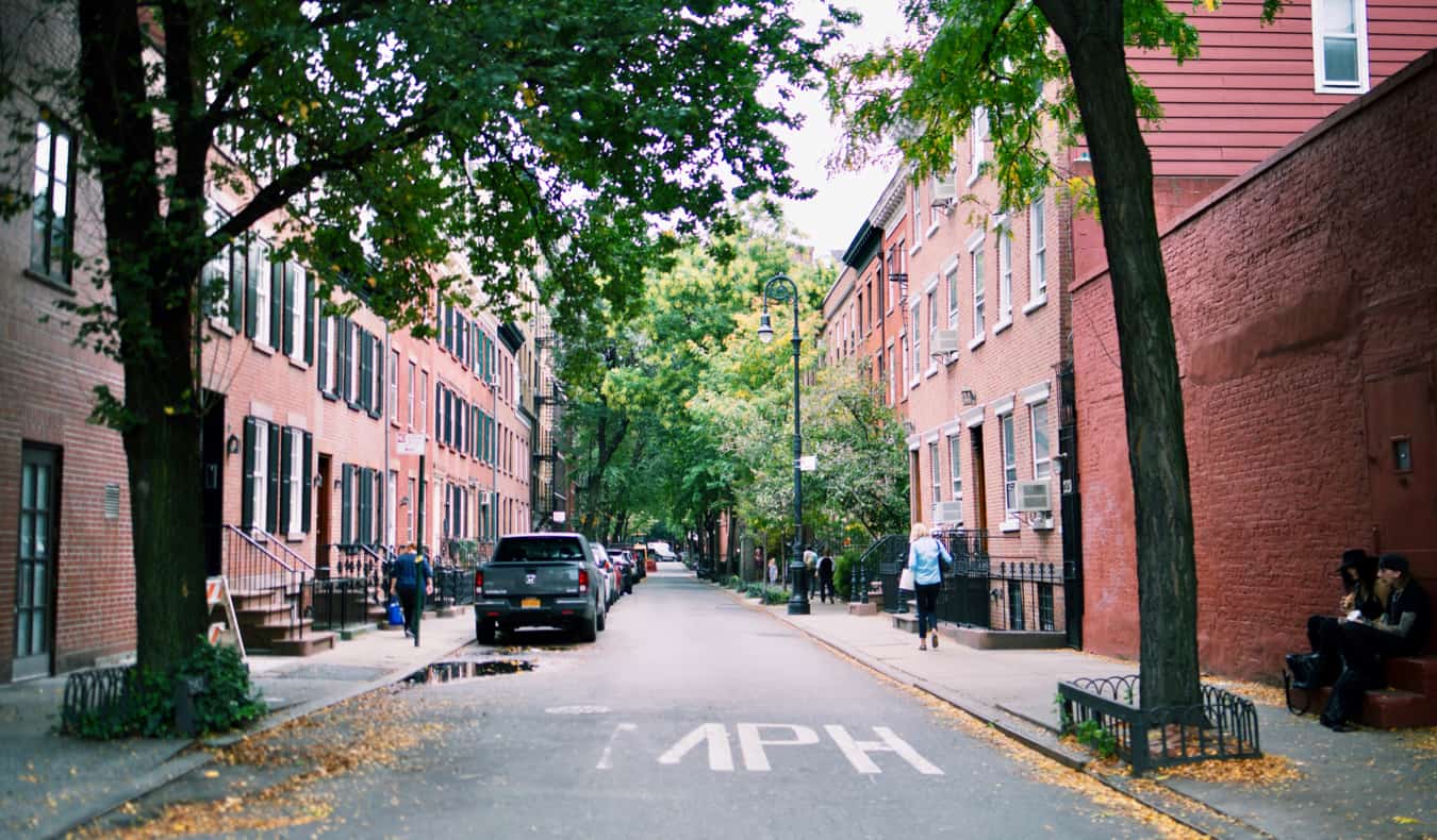 Uma rua sinuosa com edifícios de tijolos vermelhos em Greenwich Villid em Nova York