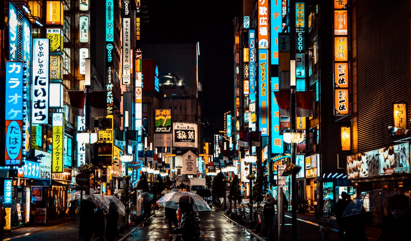 Ruas movimentadas de Tóquio, Japão, iluminadas à noite com centenas de cartazes coloridos