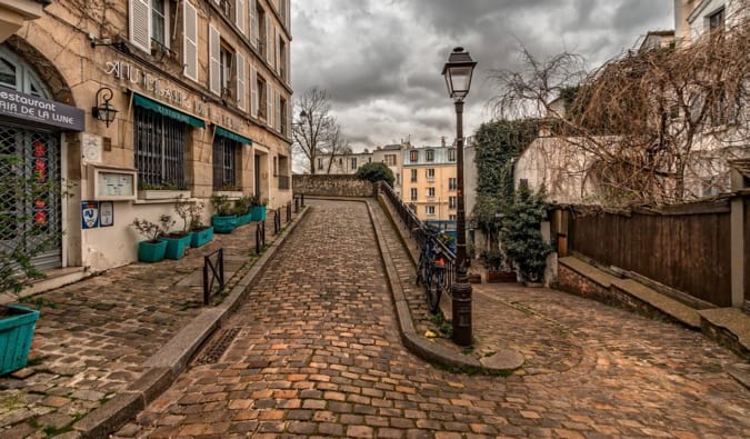 Uma das muitas ruas estreitas pavimentadas na área de Montmartra, Paris