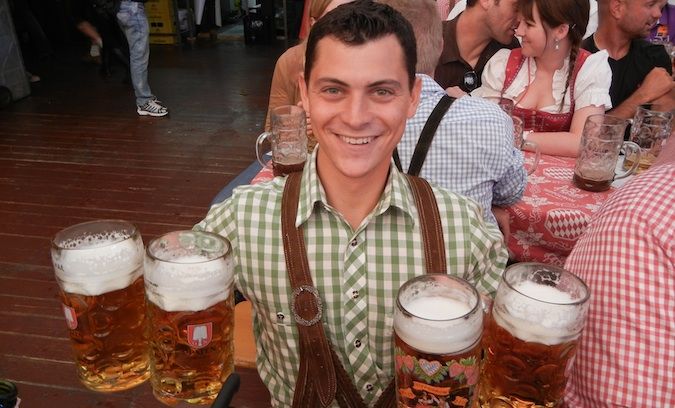 Matt Kepnes posa com 4 copos enormes de cerveja na Oktoberfest na Alemanha