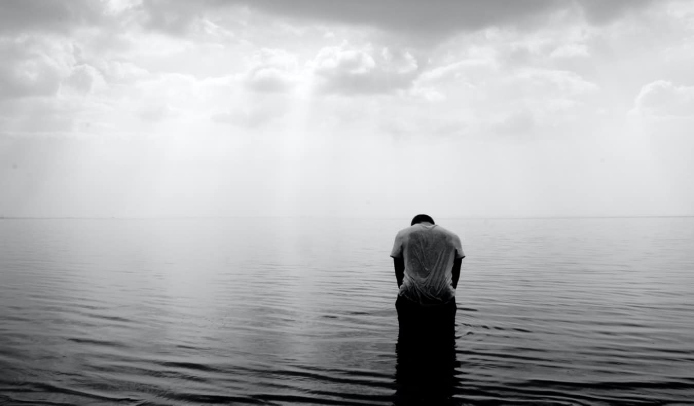 Fotografia em preto e branco de um viajante solitário na água
