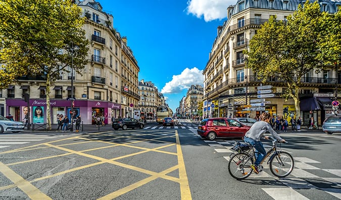Um homem anda de bicicleta pelas ruas de Paris