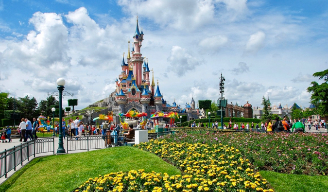 O castelo perfeito no centro da Disneylândia parisiense cercado por flores na França