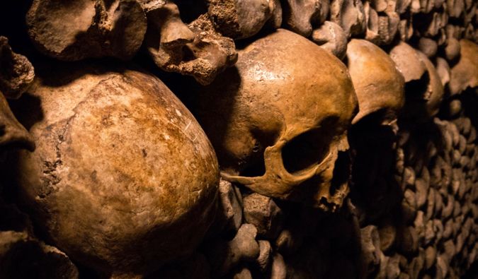Ossos e crânios antigos em catacumbas escuras em Paris, França