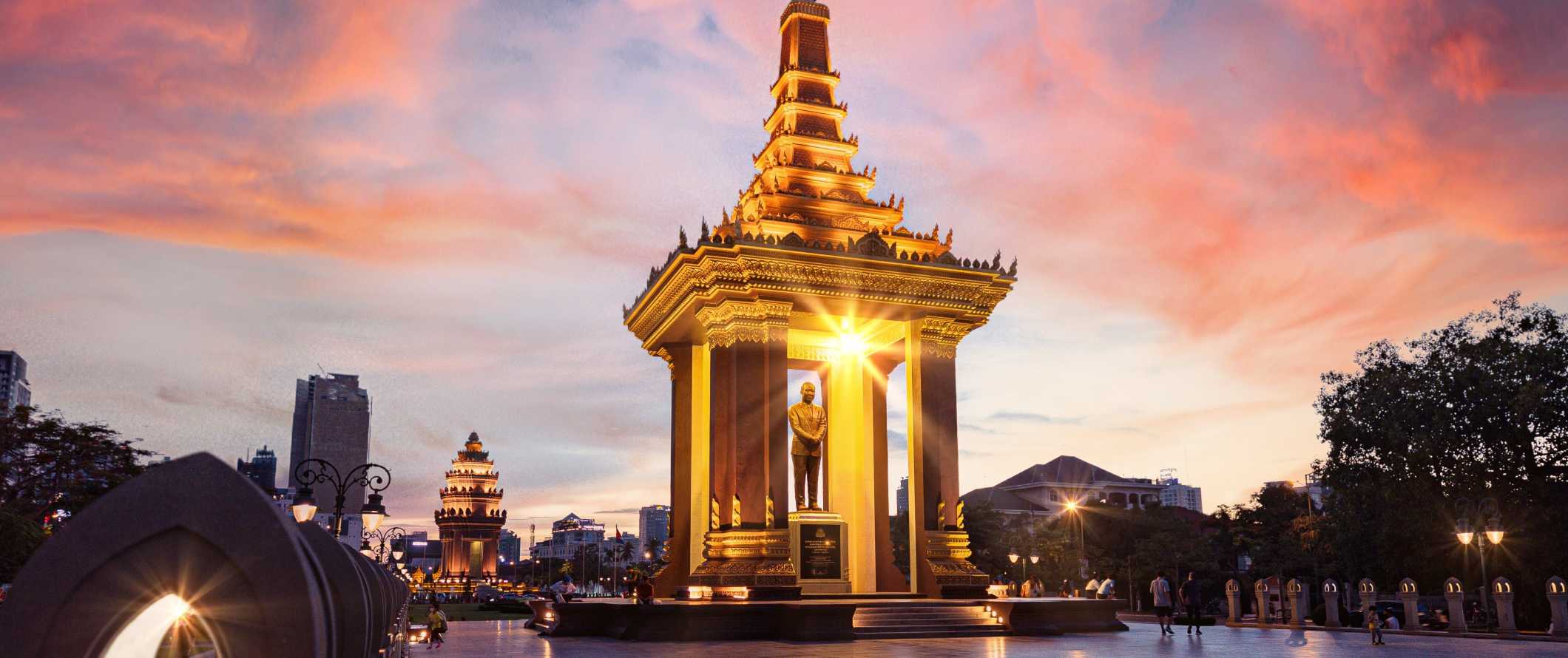 A estátua de ouro do falecido rei-pai do Norodoma Sianuka, a principal atração de Tumor-Peni, Camboja, ao pôr do sol