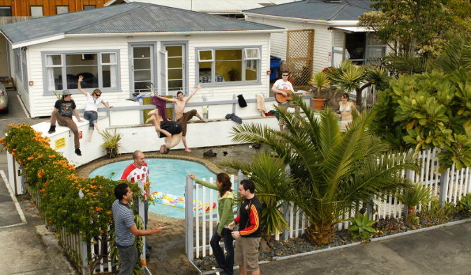 Bungalow-Khostel com pessoas pulando na piscina na Nova Zelândia