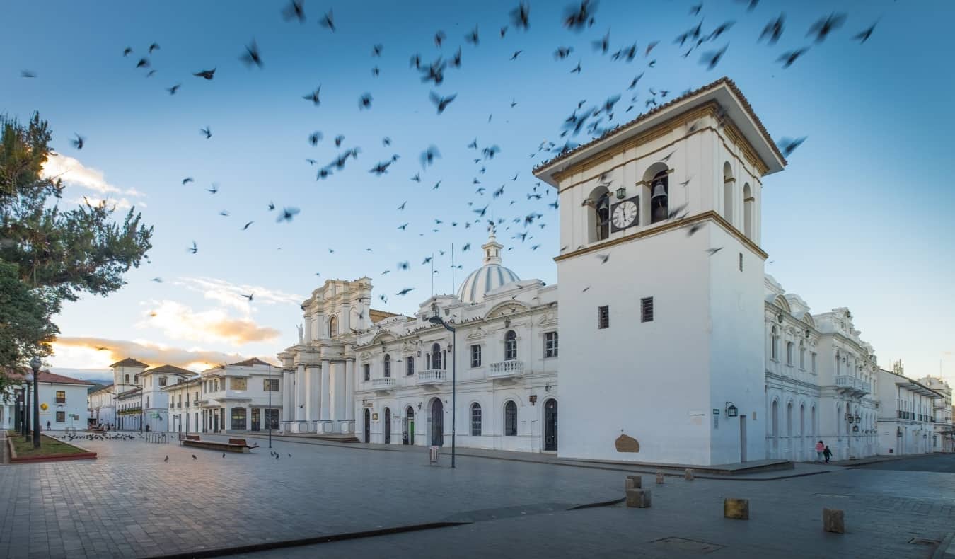 Um bando de pássaros sobrevoa os históricos edifícios brancos de Popayan, Colômbia, ao nascer do sol