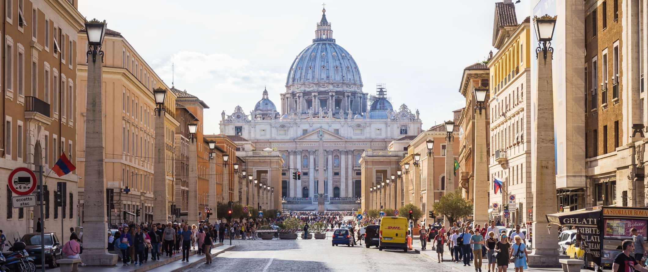 Rua larga cheia de gente com uma basílica no final em Roma, Itália