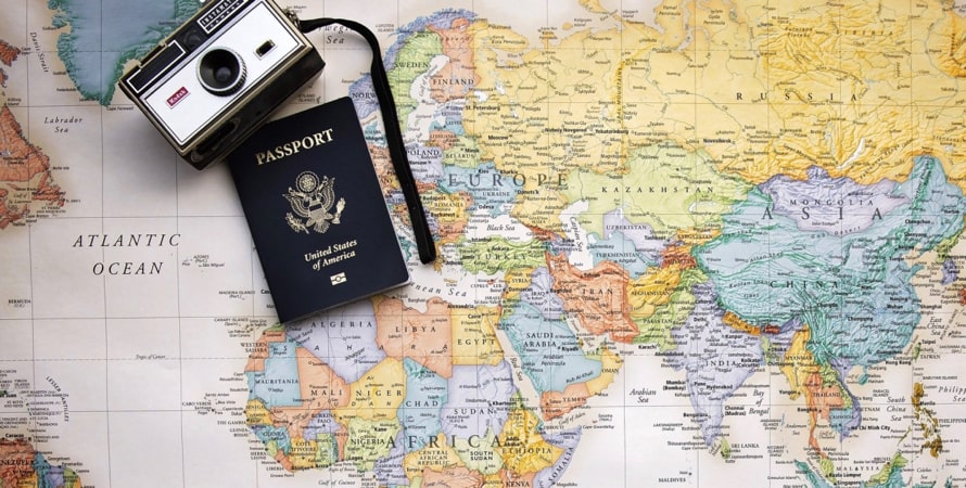 Mapa mundial com uma câmera e um passaporte sobre ele