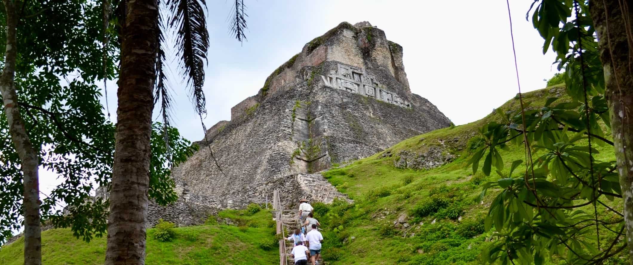 Pessoas escalam uma escada íngreme que leva a Ksunantunich, ruínas maias em San Ingo-Yignasio, Belize