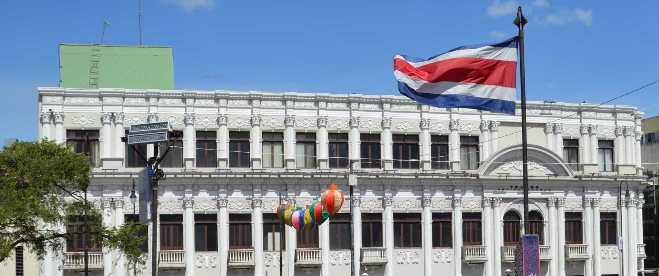 Um edifício histórico com a bandeira da Costa Rica hasteada em frente em San José, capital da Costa Rica