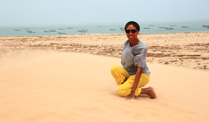 Uma professora expatriada na Arábia Saudita posa em uma duna de areia.