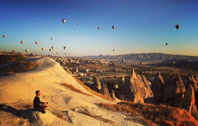Scott Dinsmore sent a-se em uma pedra na Turquia, quando balões enchem o céu