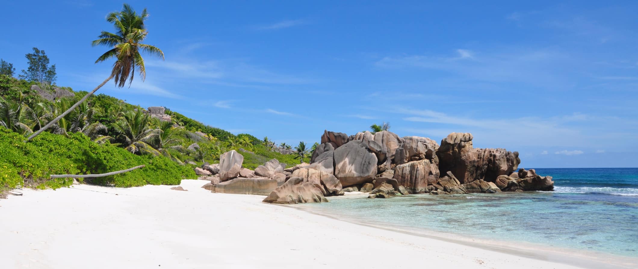 Praia tropical em seychelles com areia branca e céu azul brilhante acima da cabeça