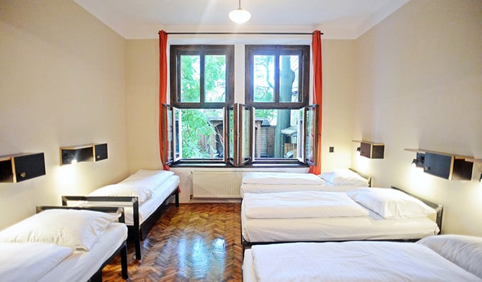 Quarto compartilhado com 5 camas de solteiro e decoração minimalista no Sir Toby Hostel
