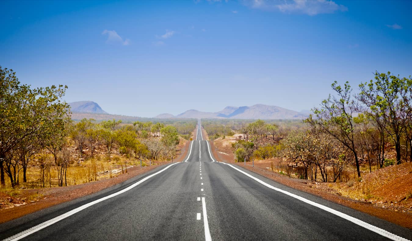 Uma estrada aberta no interior da Austrália em um dia ensolarado brilhante
