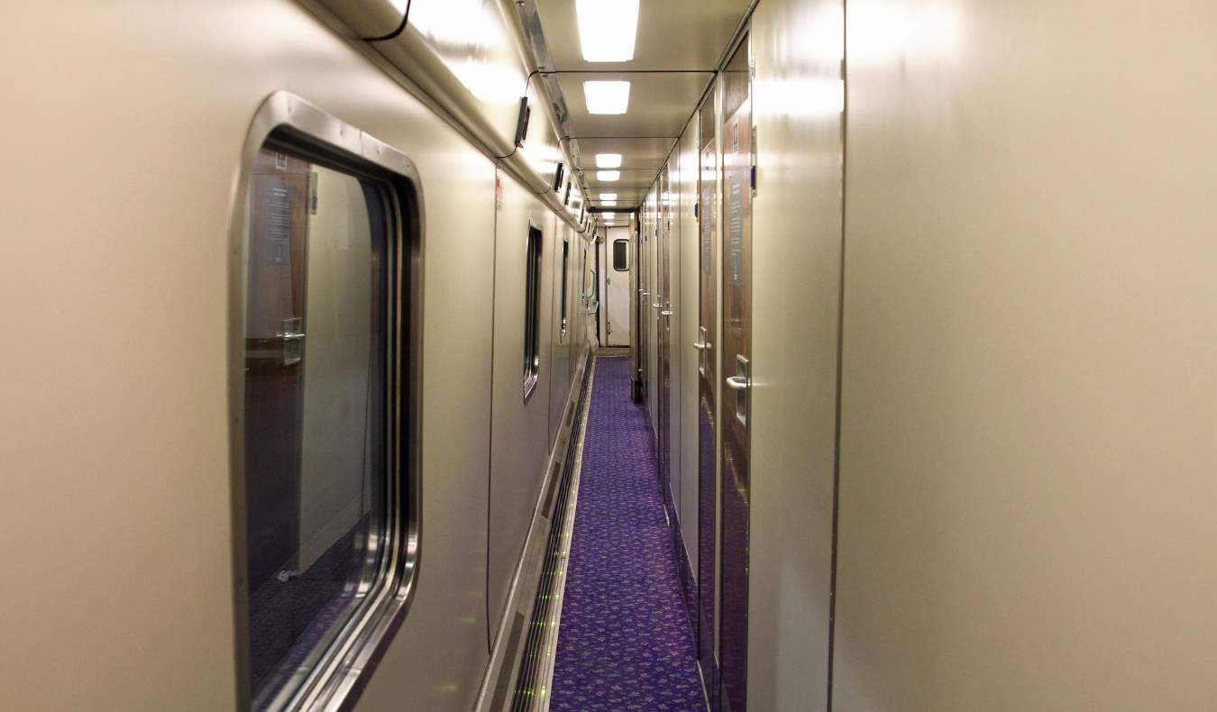 Longo corredor de trem com portas para compartimentos de dormir