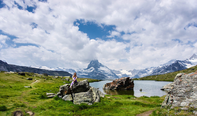 Um único viajante fica em uma pedra contra uma bela paisagem no exterior