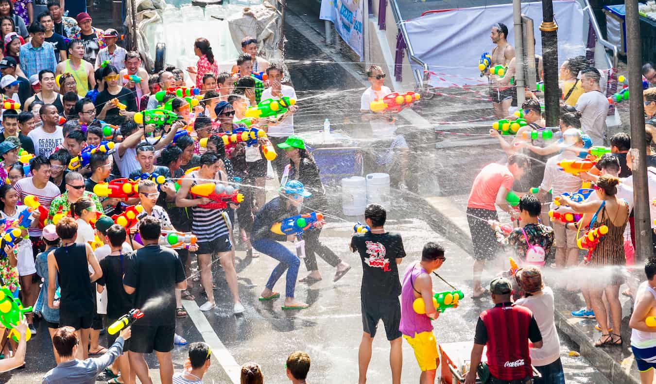 Pessoas disparam armas de água e jogam água umas nas outras durante Songkran na Tailândia