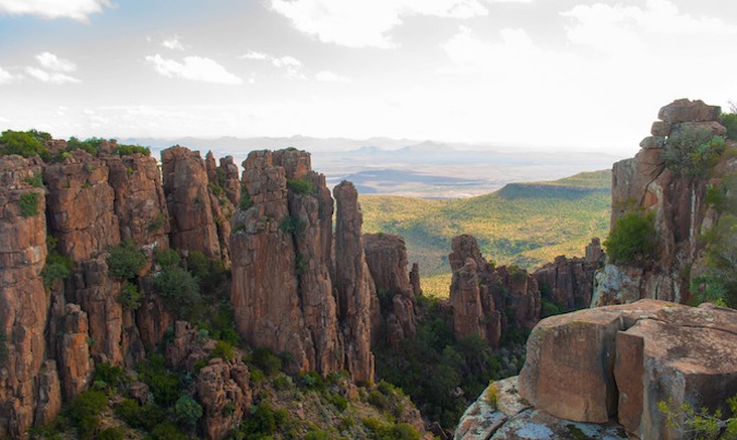 Altas formações rochosas nas colinas da África do Sul, levando a um amplo vale