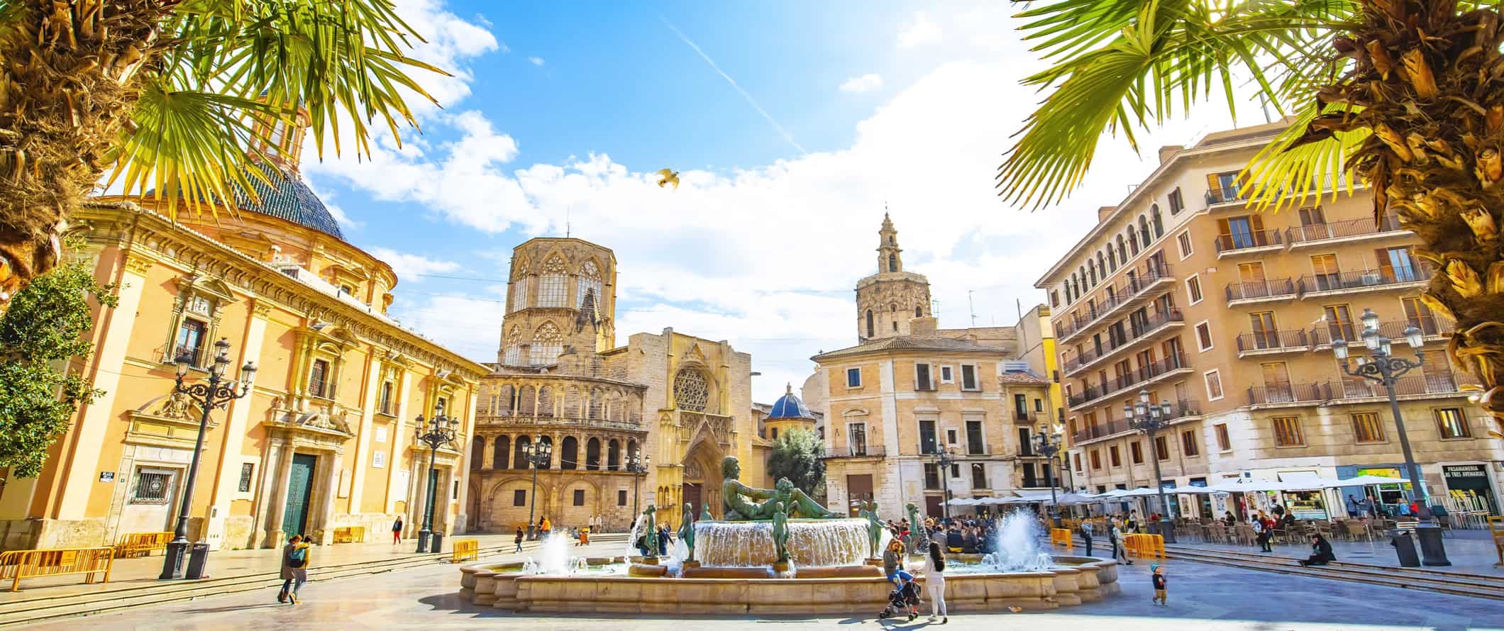 Cena de rua calma na ensolarada Valência, Espanha, com edifícios históricos e moradores passeando