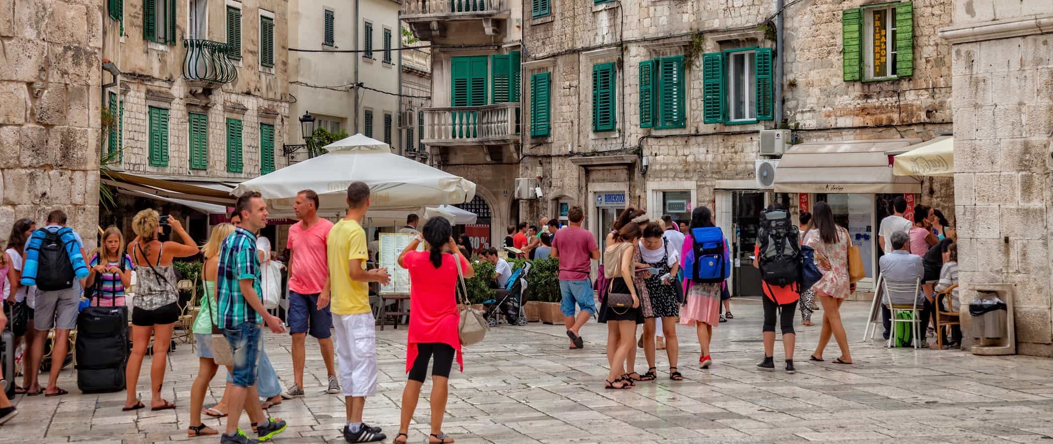 As pessoas andam ao longo de uma estreita rua antiga em Split, Croácia