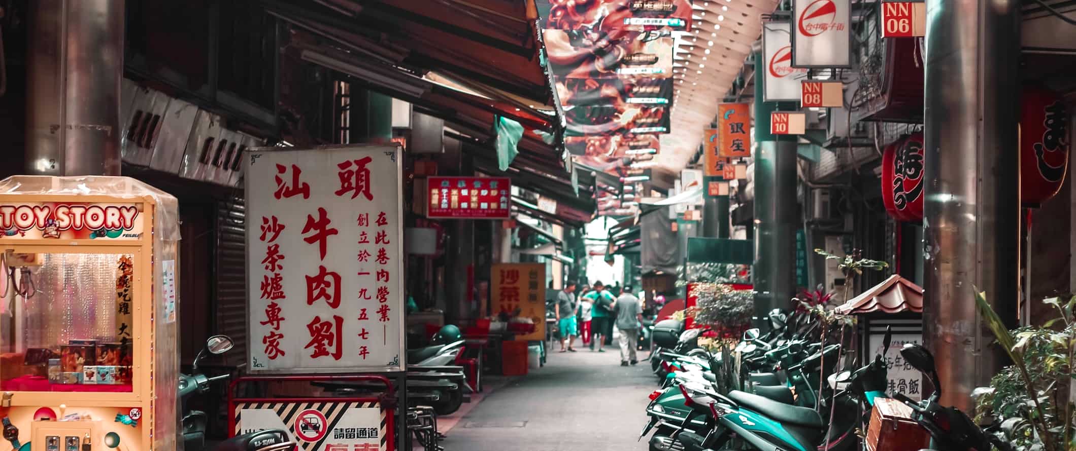 Uma rua estreita repleta de scooters e lojas na movimentada Taiwan