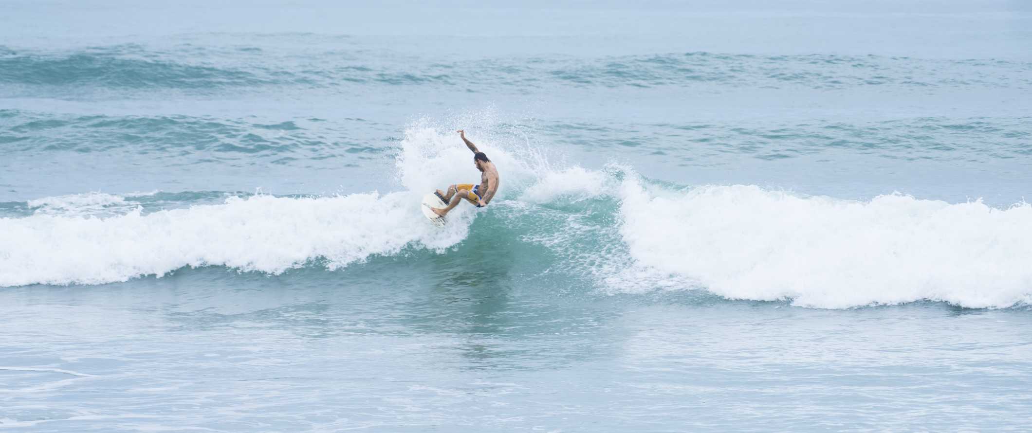 Um surfista pega uma onda na costa de Tamarindo, na Costa Rica