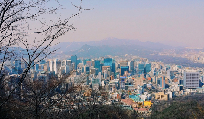 Vista da cidade de Seul, Coréia, com galhos de árvores em primeiro plano