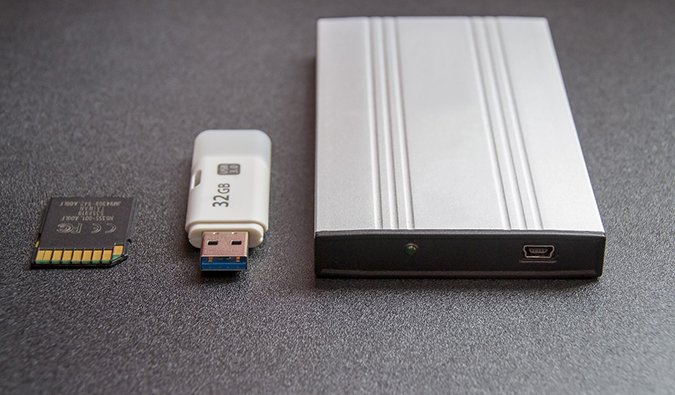 Foto de vários dispositivos de backup, incluindo um disco rígido externo