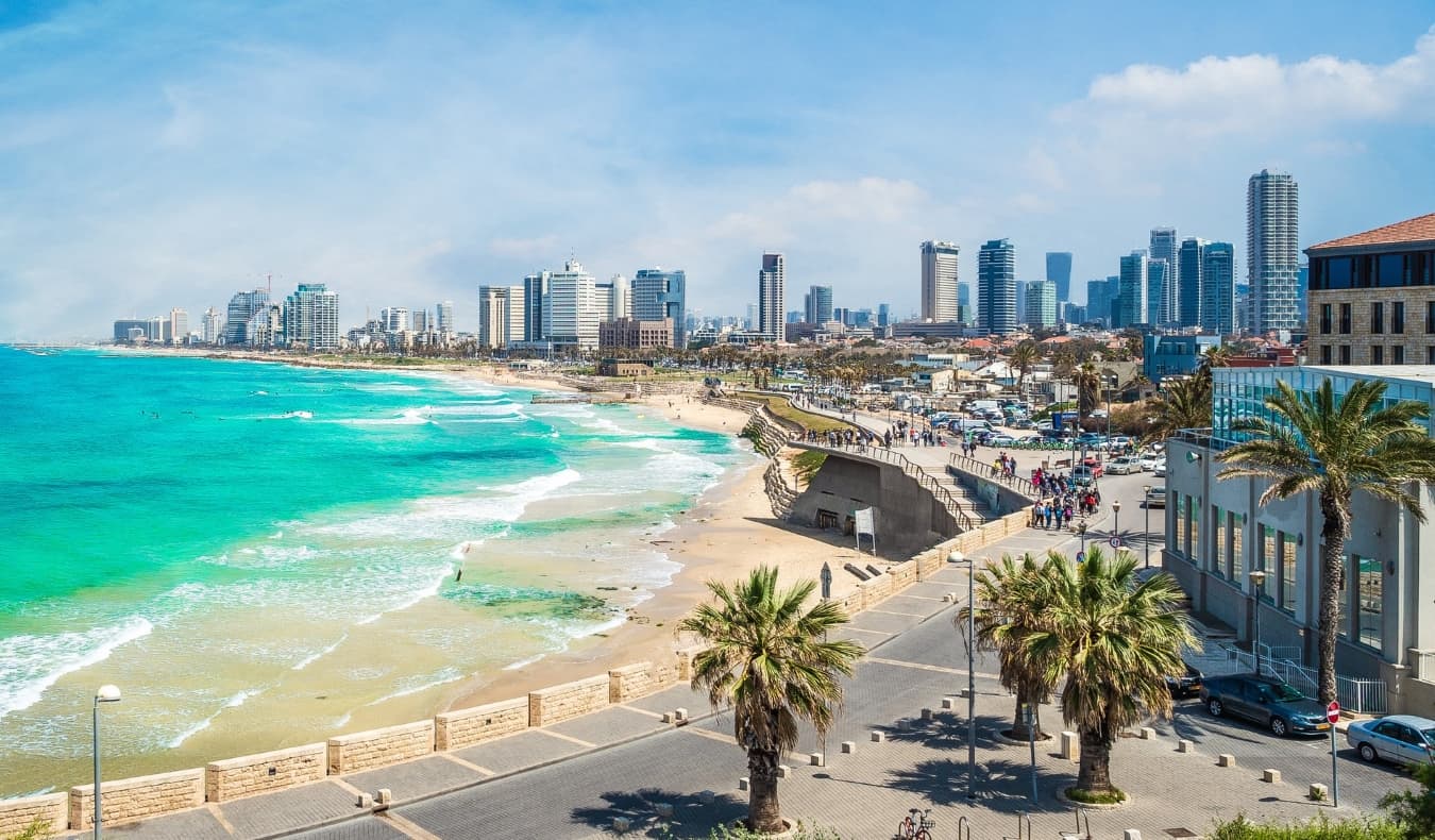 Paisagem da cidade em Tel Aviv, Israel, com uma praia em forma de ferradura, oceano azul e arranha-céus ao fundo