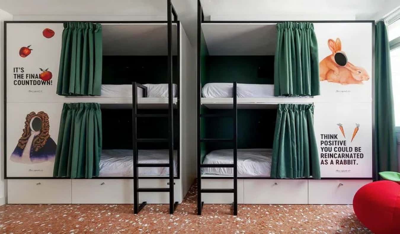 Dois beliches estilo cápsula com citações e imagens de Isaac Newton e coelhinhos no 2060 The Newton Hostel em Madrid, Espanha.