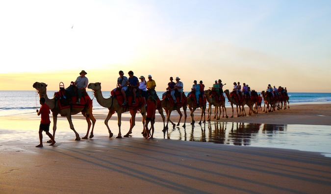 Uma série de camelos vai ao longo da praia em Marrocos