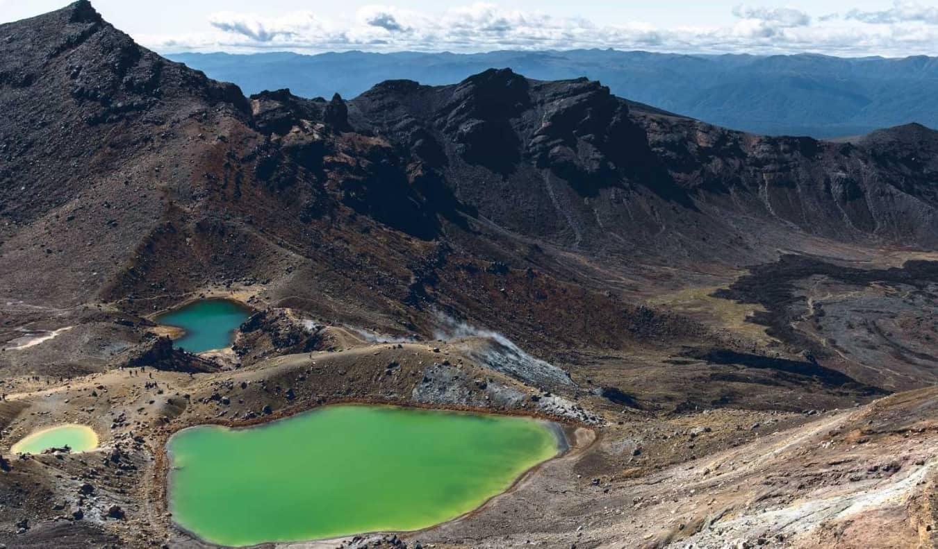Emerald Green Lakes no cenário da severa paisagem vulcânica da transição da montanha de Tongariro, uma campanha na Nova Zelândia