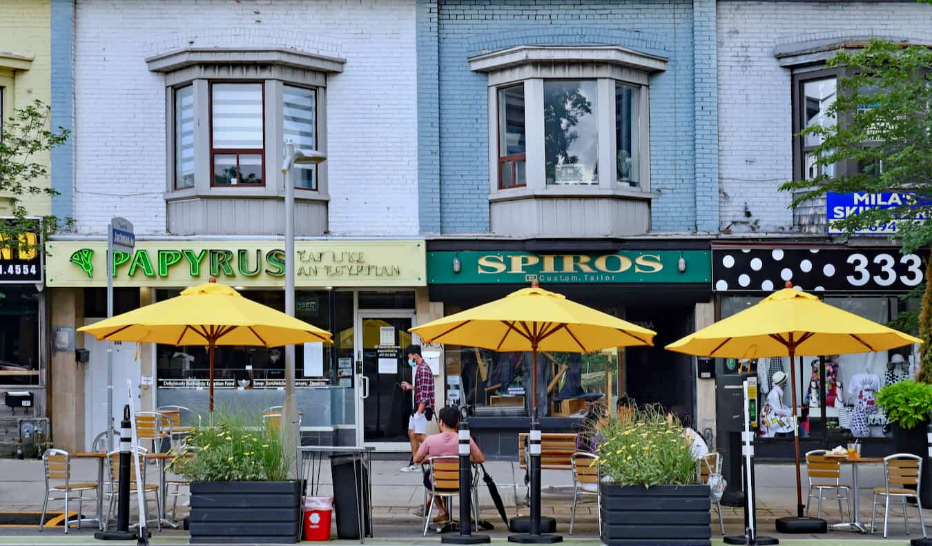 Pessoas relaxam em um restaurante na rua na área de Danforth, em Toronto, Canadá