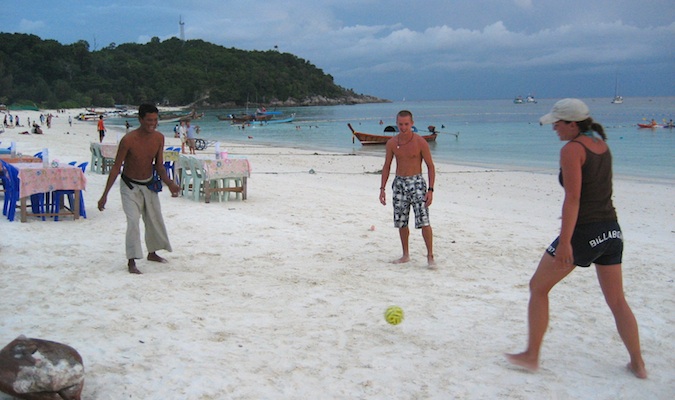 Mochileiros econômicos jogam futebol na praia de Koh Lipe