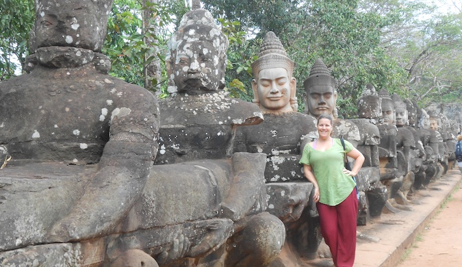 Uma mulher-mulher solitária posa perto de estátuas religiosas enquanto viaja pelo mundo