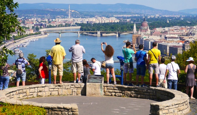 Turistas tiram fotos com vista para uma cidade na Europa