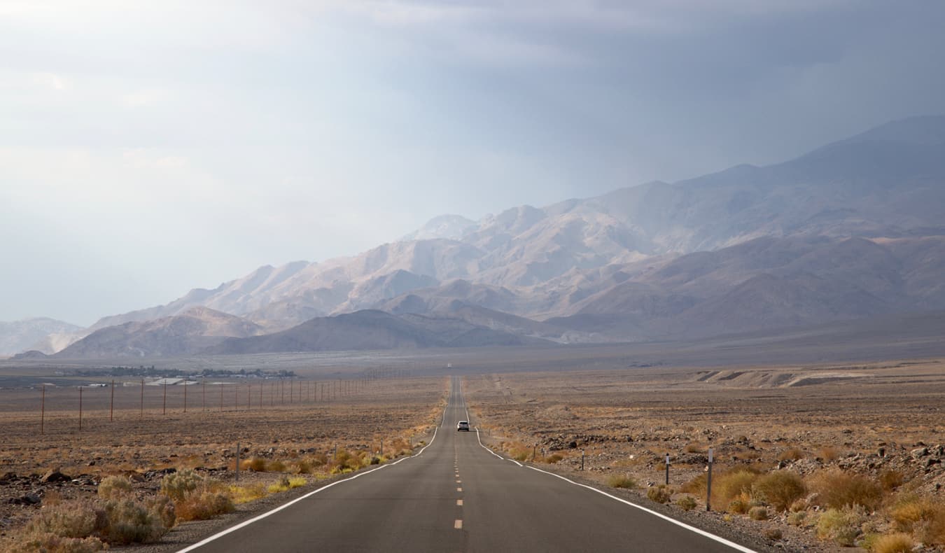 Um carro em uma estrada aberta no vale da morte, EUA