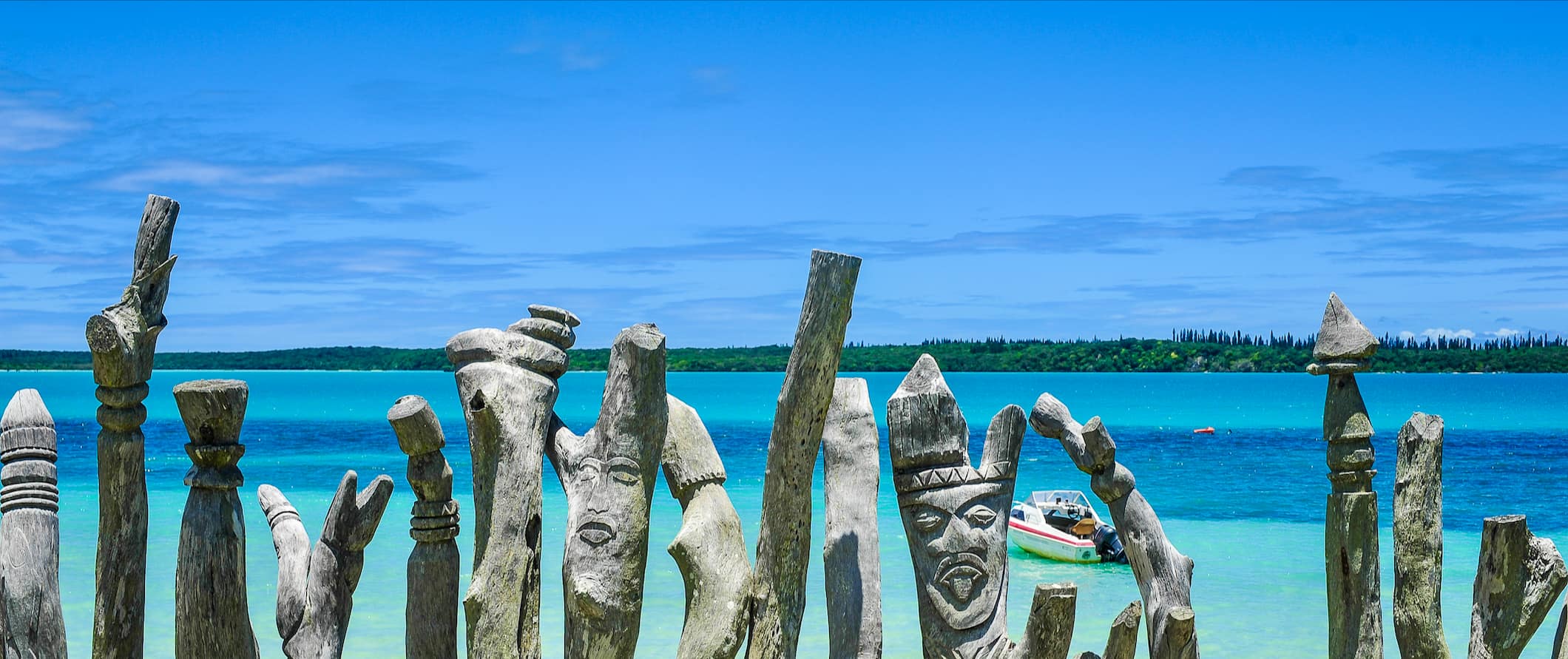 Colunas de madeira esculpidas à beira-mar na ensolarada e brilhante Vanuatu