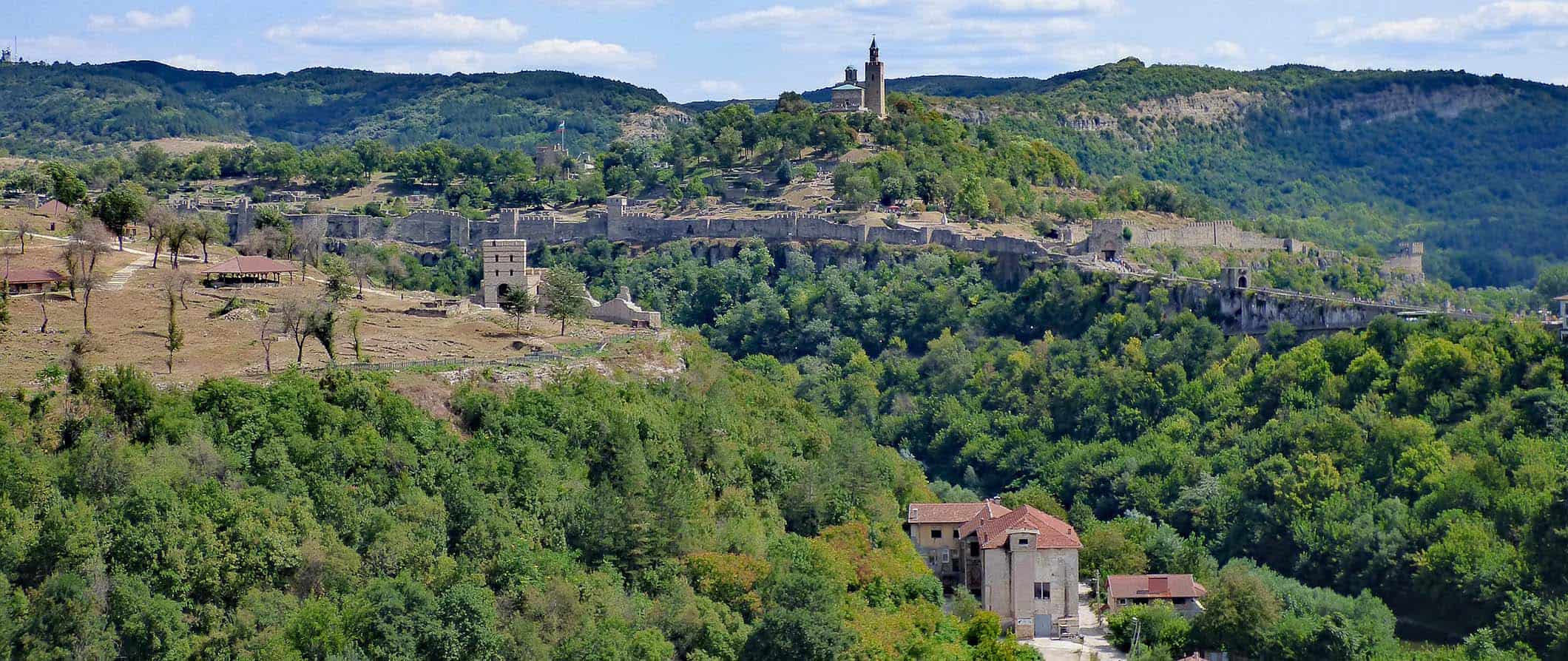 Fortaleza histórica com vista para Veliko Tarnovo, Bulgária, cercada por árvores e colinas