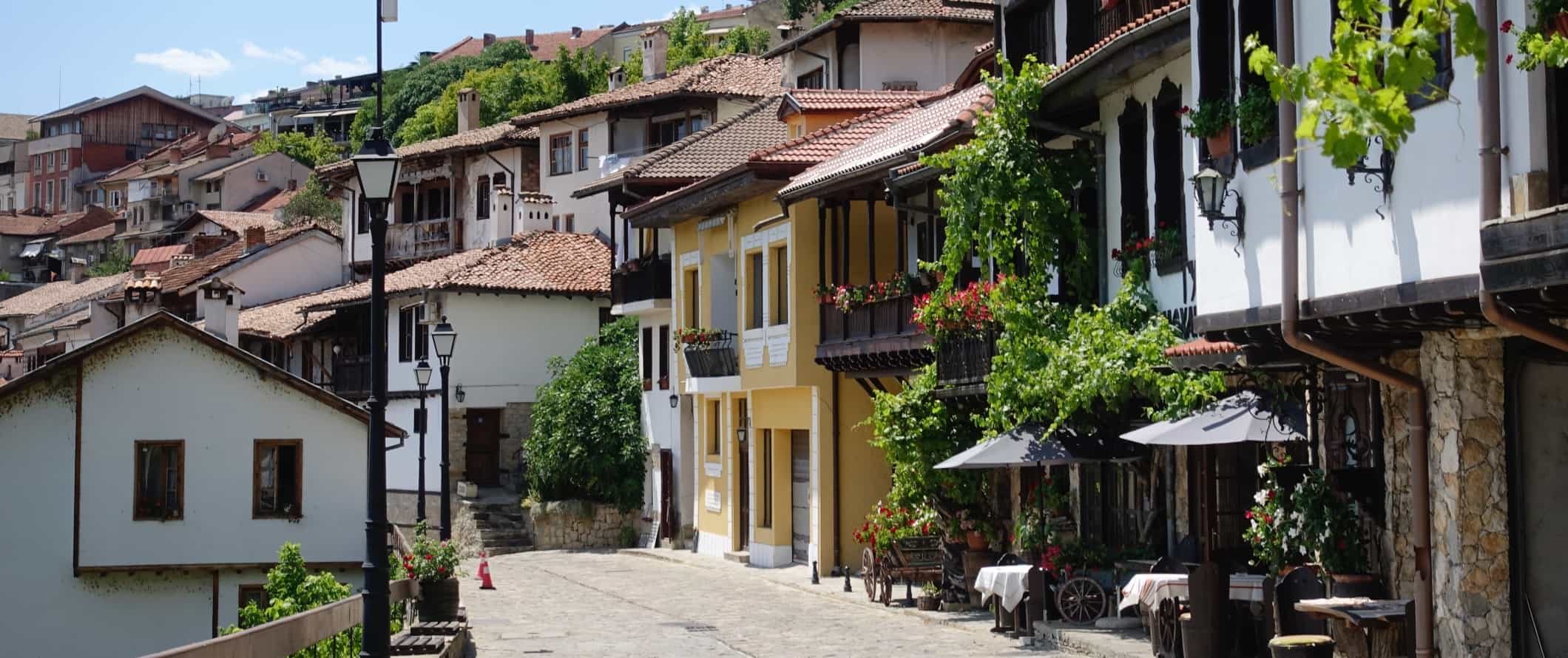 Rua de paralelepípedos com casas tradicionais e restaurantes na cidade velha de Veliko Tarnovo, Bulgária